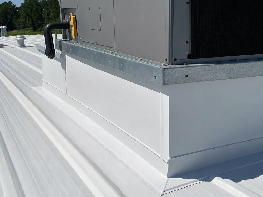 Commercial rooftop unit curb with neat flashing terminations and sealant work following the roof slope